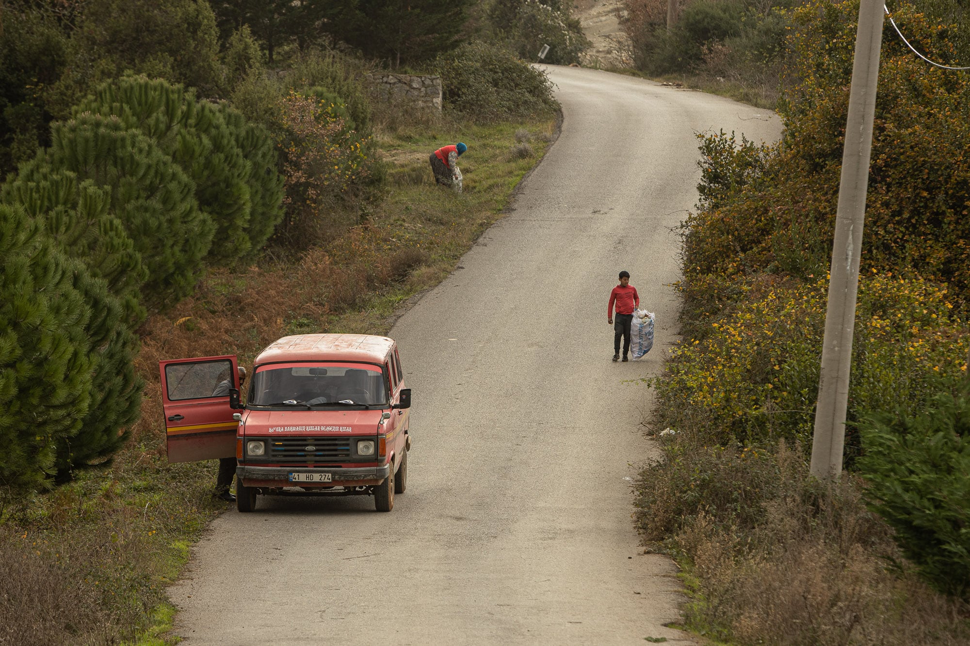 People cleaning the road of trash near Pinarli