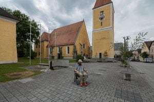 I sit in front of the free standing church tower of Feldkirchen